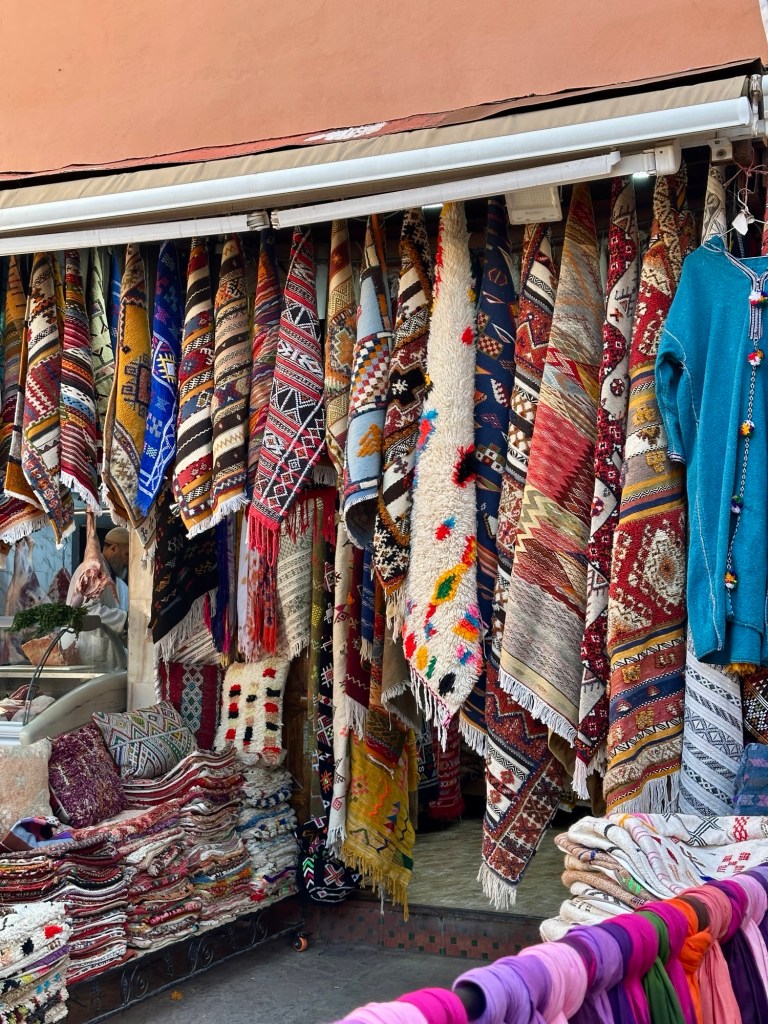 View of Marrakech streets with motorbikes, pedestrians, and historic buildings creating a busy urban atmosphere